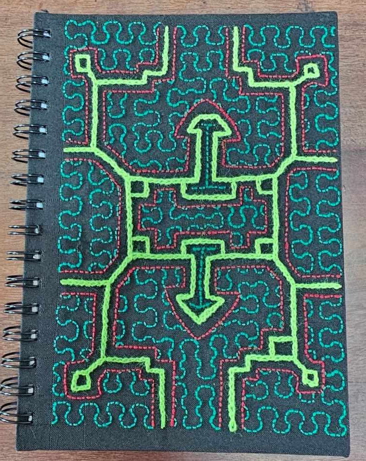 Notebook with green and red circuit board design on a wooden surface